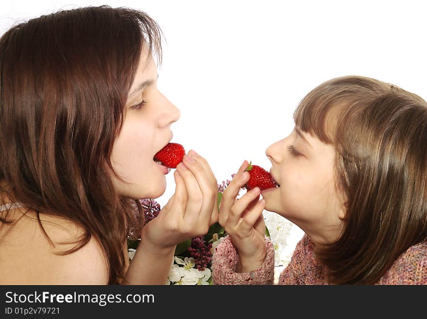 Two little girls eating a strawberries