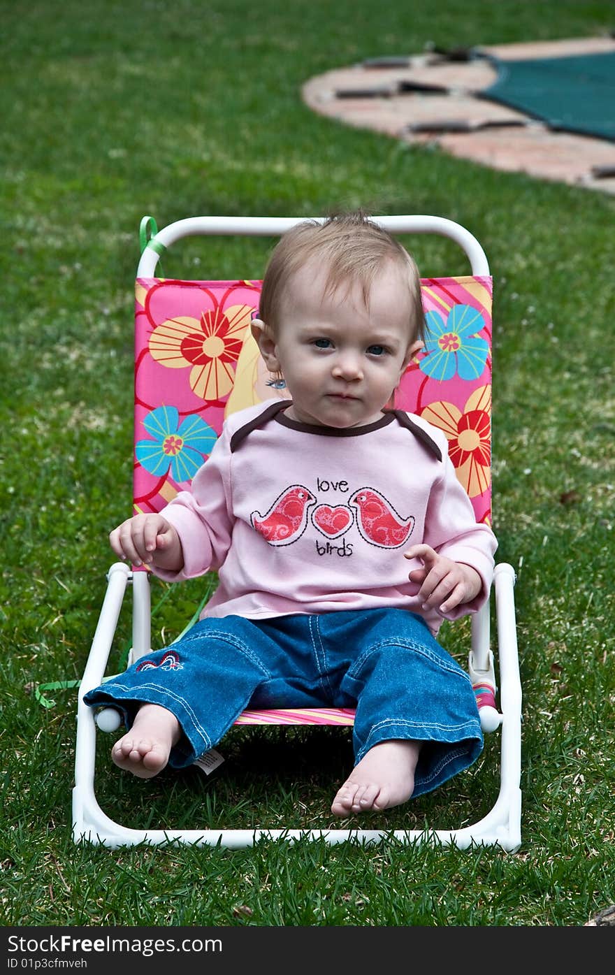 Little girl sitting in a chair. Little girl sitting in a chair