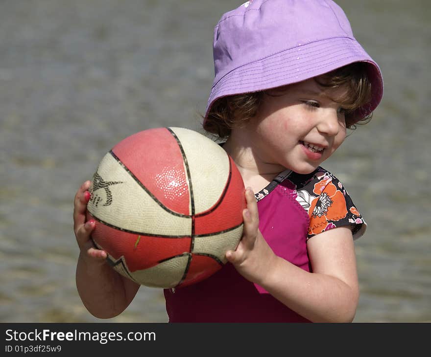 Little girl playing ball.