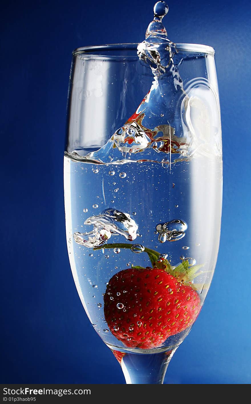 Strawberries falls in goblet with water. Strawberries falls in goblet with water