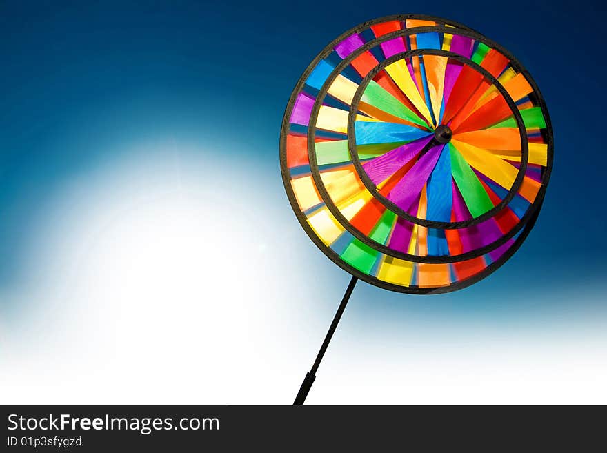 Plastic colourful pinwheel on the blue and white background