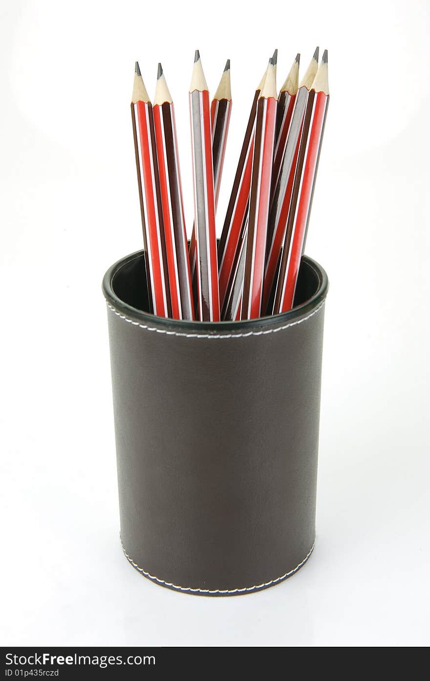 Lead pencils in a cup holder isolated against a white background. Lead pencils in a cup holder isolated against a white background