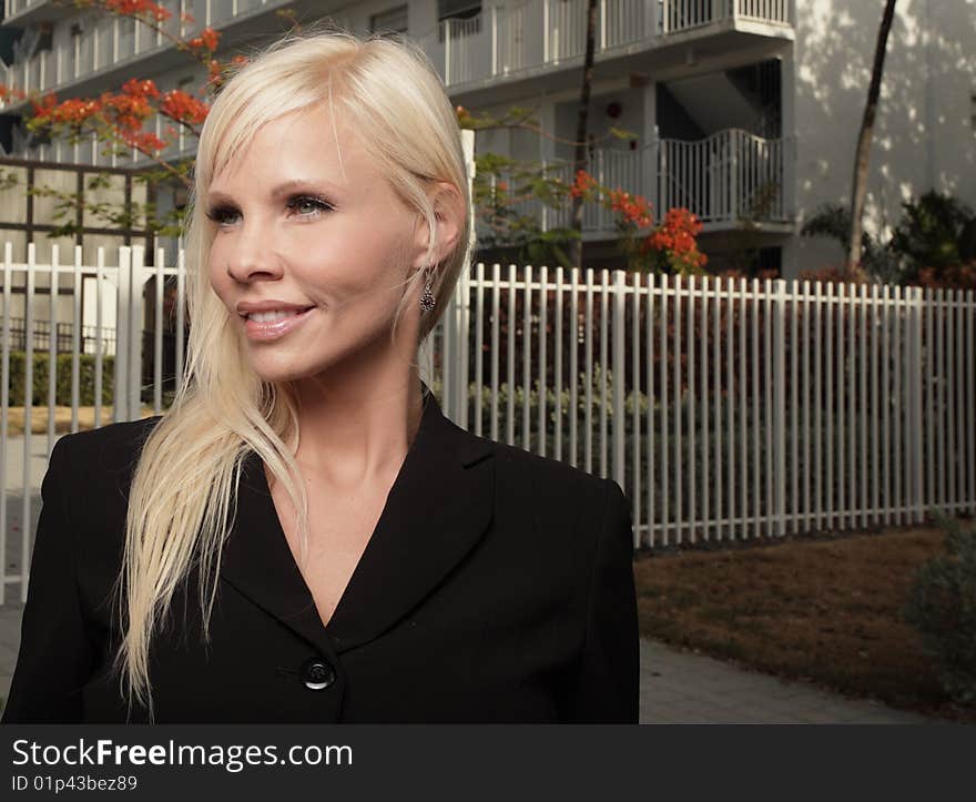 Young businesswoman outside smiling and glancing away. Young businesswoman outside smiling and glancing away