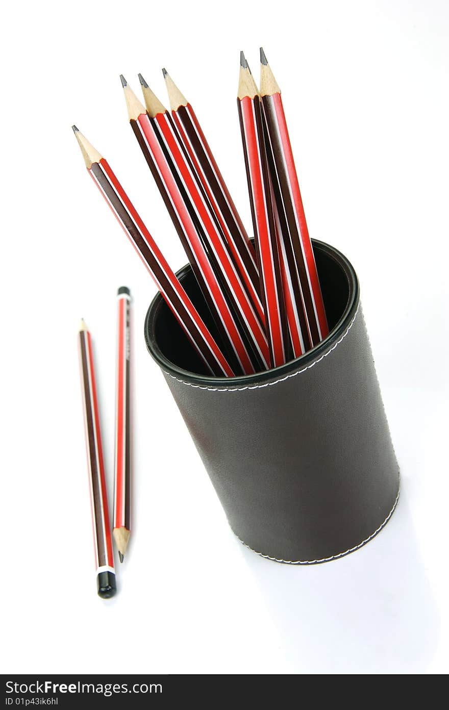 Lead pencils in a cup holder isolated against a white background. Lead pencils in a cup holder isolated against a white background