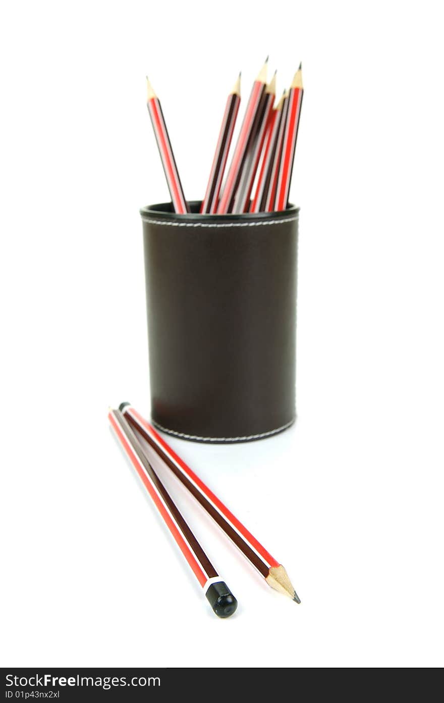 Lead pencils in a cup holder isolated against a white background. Lead pencils in a cup holder isolated against a white background