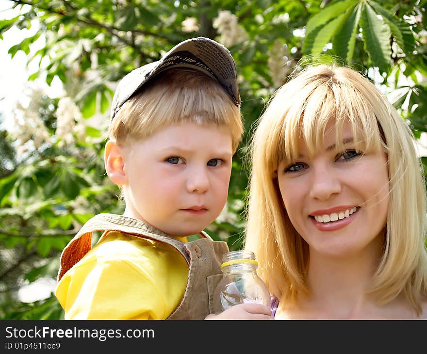 Woman and young boy outdoors embracing and smiling. Woman and young boy outdoors embracing and smiling