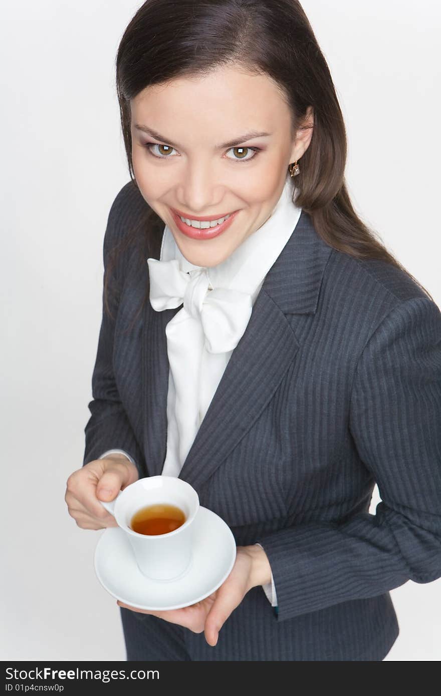 The woman in a business suit holds a cup with tea