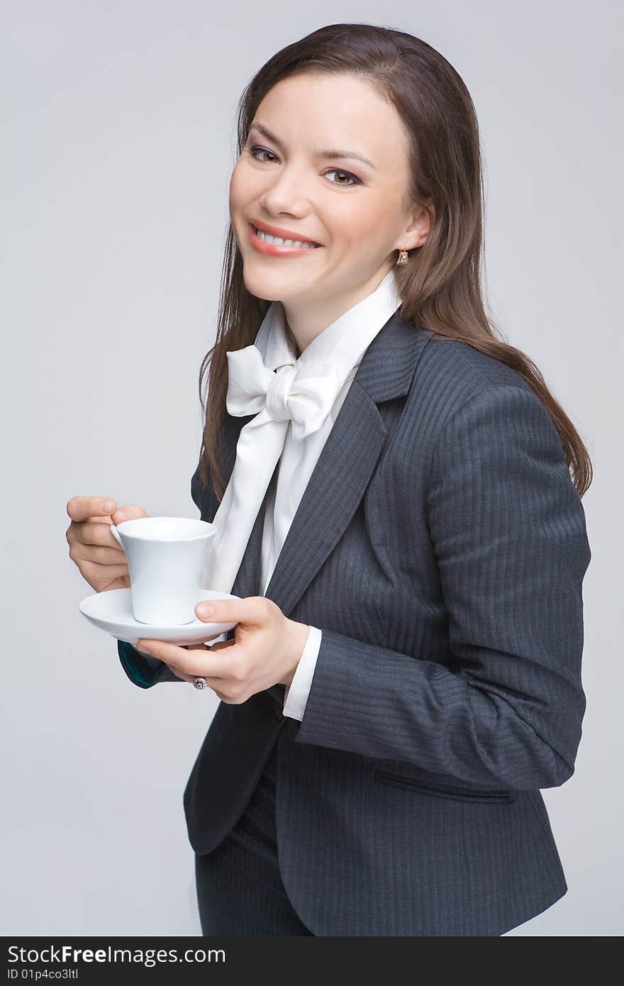 The woman in a business suit holds a cup with tea