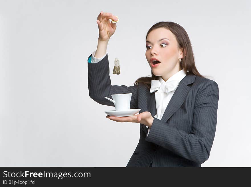 The woman in a business suit holds a cup with tea