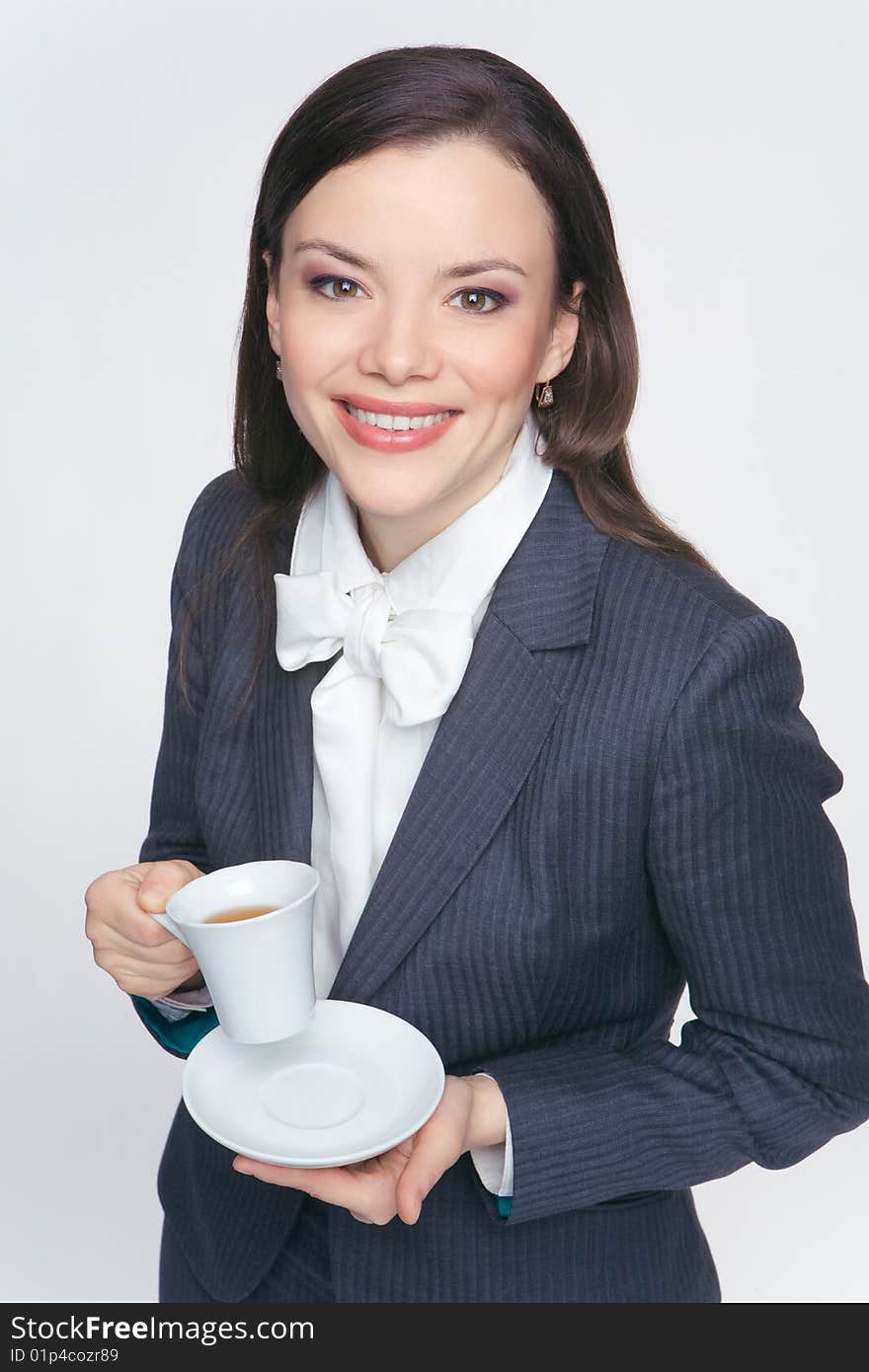 The woman in a business suit holds a cup with tea