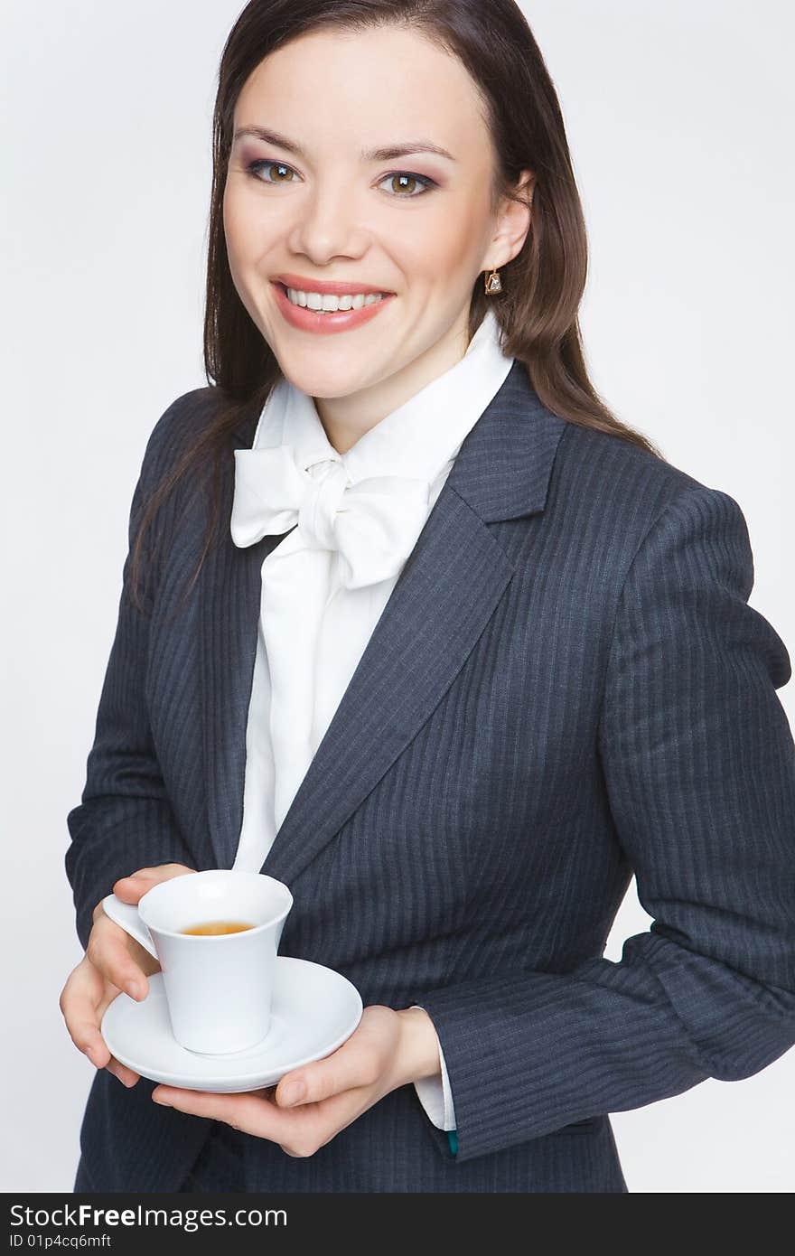 The woman in a business suit holds a cup with tea