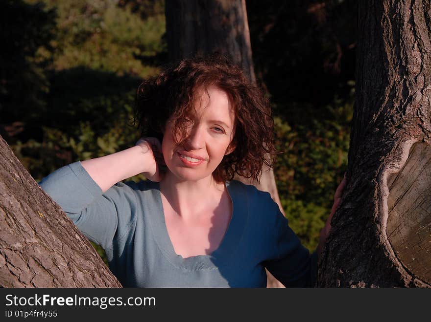 Women put her arm to the tree feel good and relax in bright sunshine. Women put her arm to the tree feel good and relax in bright sunshine