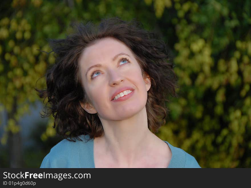 Woman looking up to sky and wind move her hair gently. Woman looking up to sky and wind move her hair gently