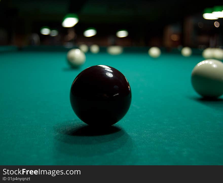 Black ball for playing billiards on green table. Black ball for playing billiards on green table