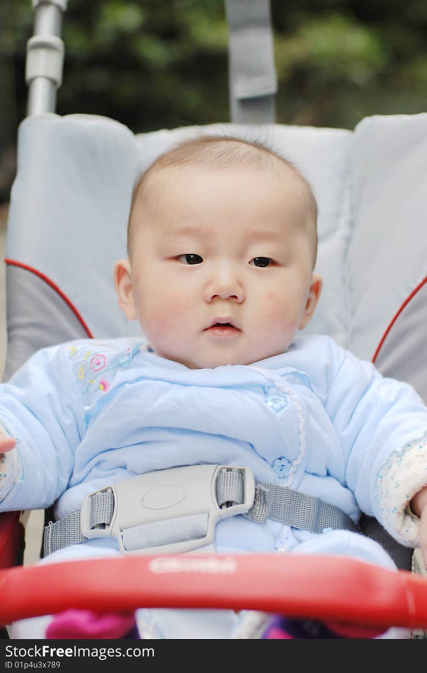 Cute baby boy sit in  baby carriage