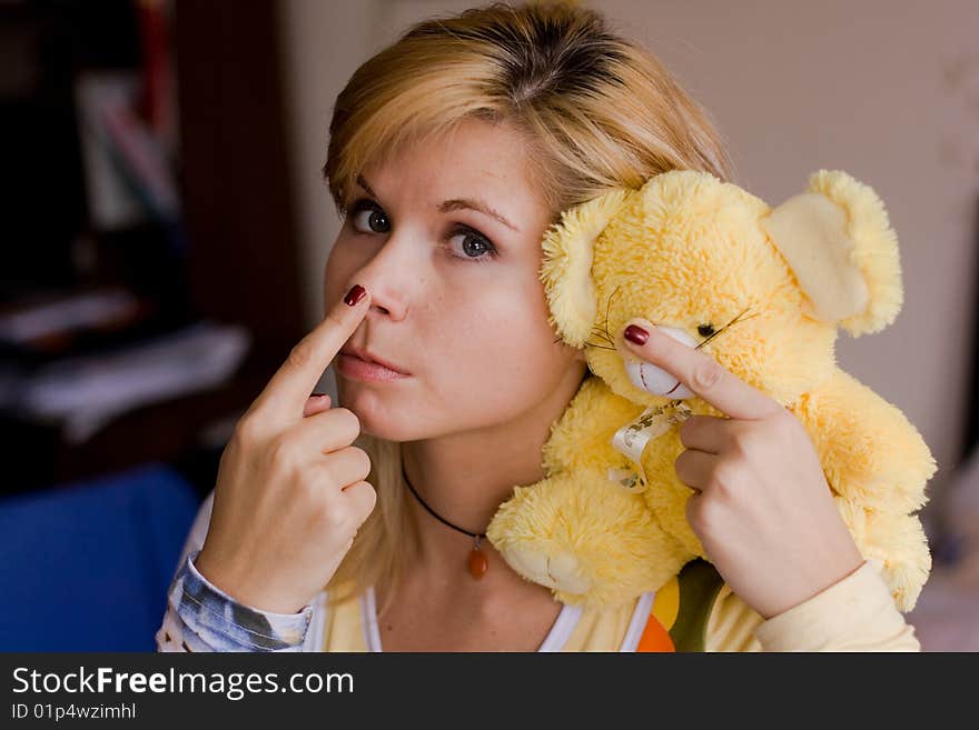 A girl holds a yellow toy-bear. A girl holds a yellow toy-bear