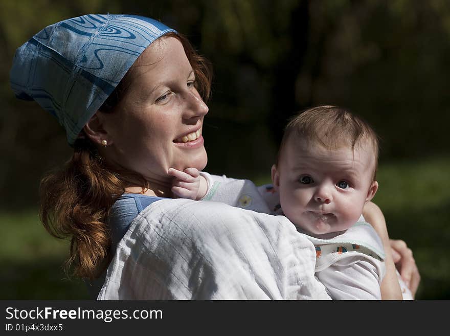 Smiling young lady carrying the baby infant. Smiling young lady carrying the baby infant