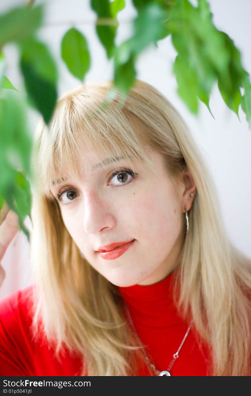 An attractive girl's portrait, her face seen through some green leaves. An attractive girl's portrait, her face seen through some green leaves