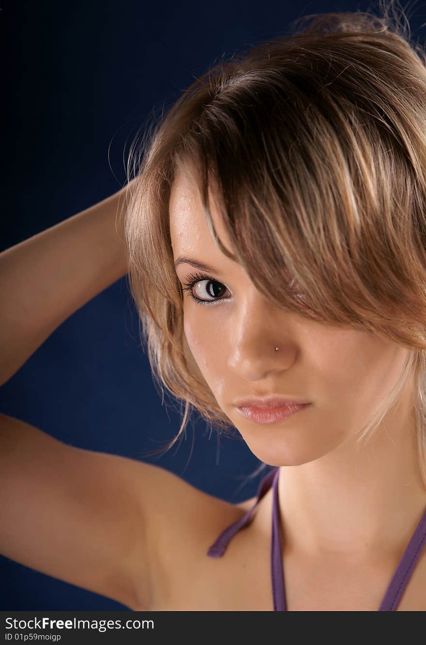 The portrait of the beautiful girl is photographed on a dark blue background