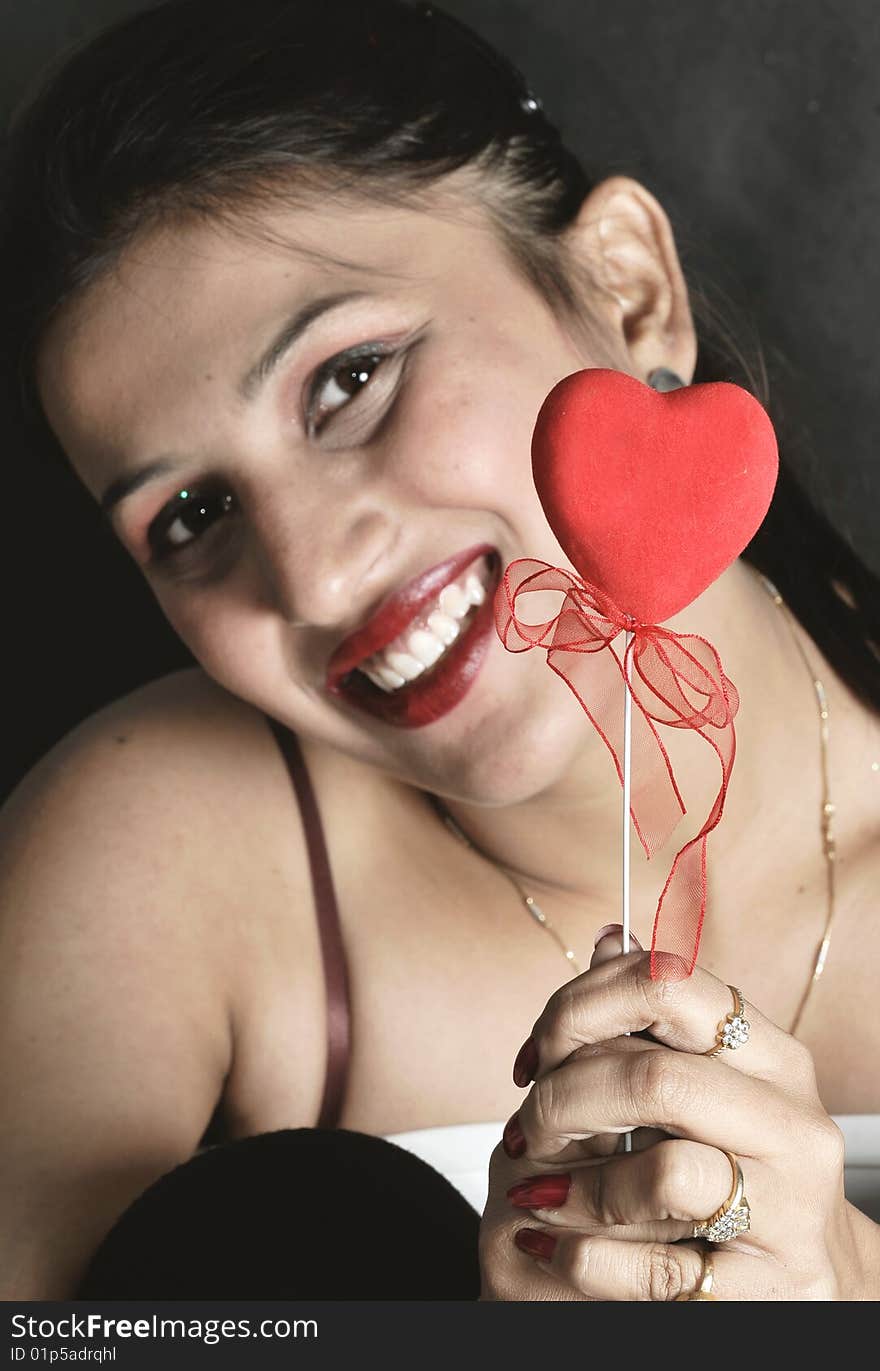 Girl with heart posing in studio.