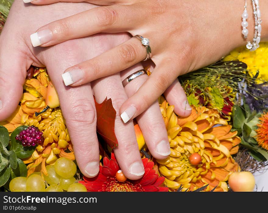 Newly wed couple showing off thier rings over a bouquet of flowers. Newly wed couple showing off thier rings over a bouquet of flowers