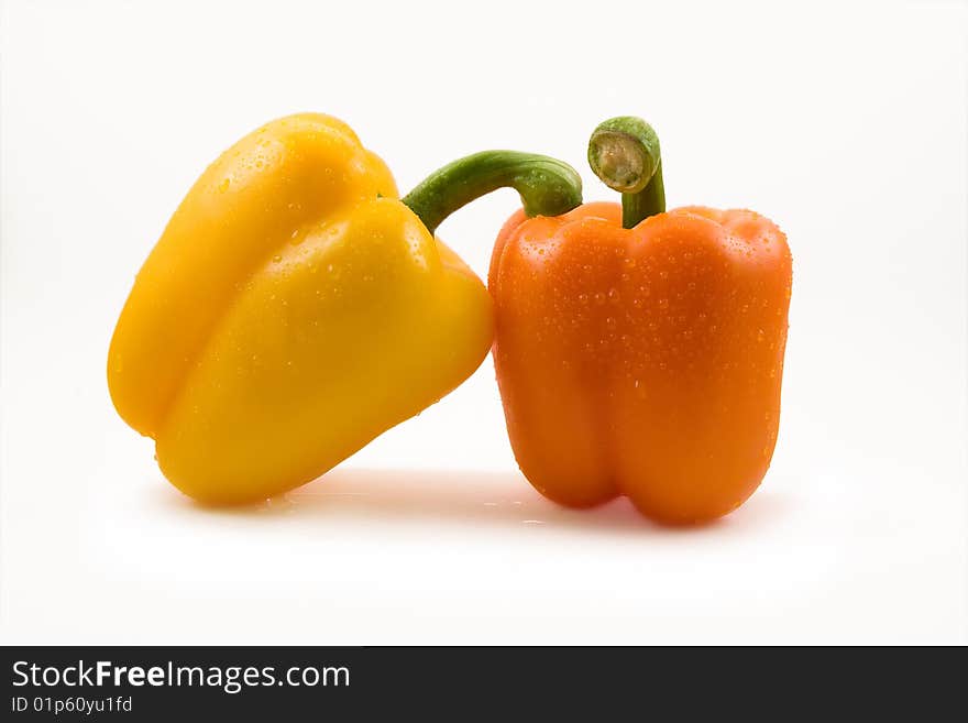 Yellow and orange peppers in caring pose. Yellow and orange peppers in caring pose