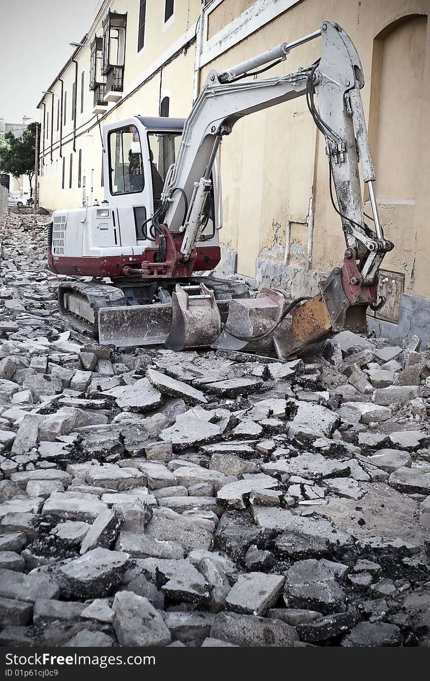 Excavating machine destroying the asphalt of a street. Excavating machine destroying the asphalt of a street