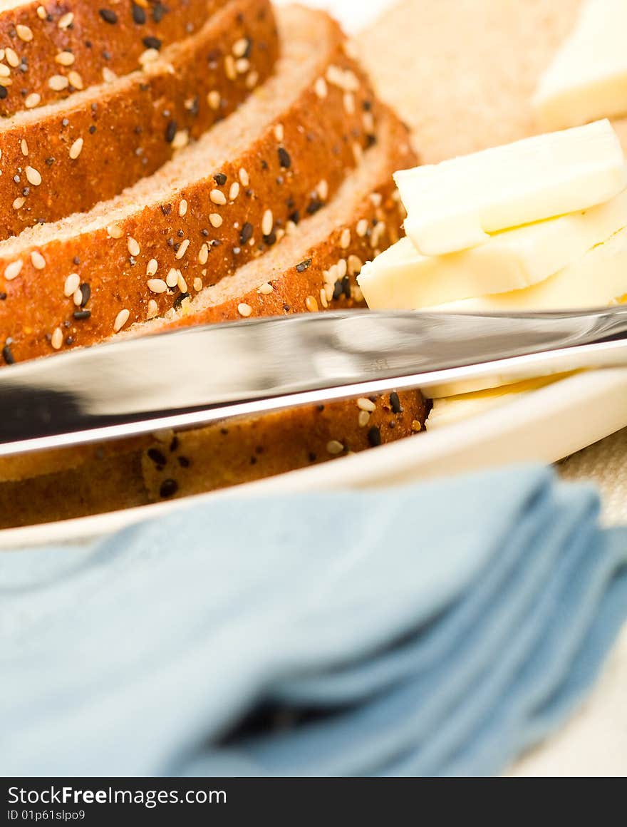 Multi-grain wheat Bread stacked on blue plate with butter and knife. Multi-grain wheat Bread stacked on blue plate with butter and knife