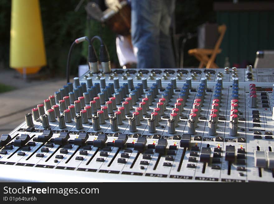 Mixer and in the background, the musicians play