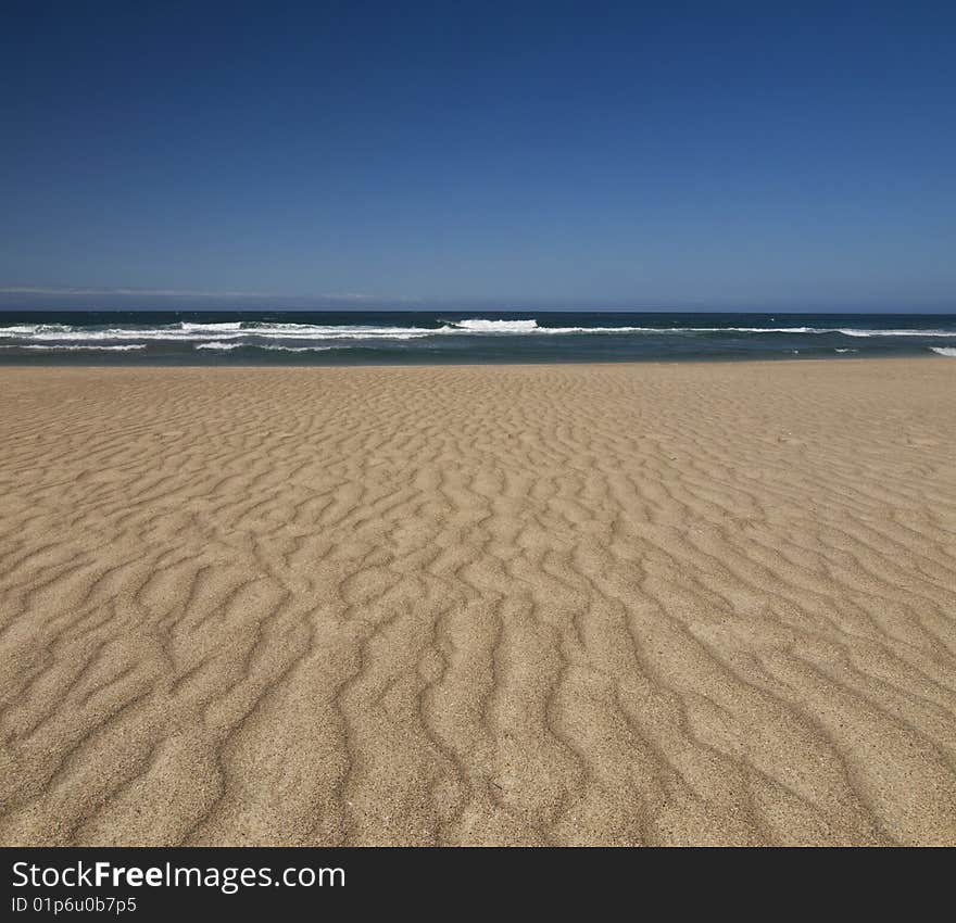 The wind produces a relief on the sand of this desert beach. The wind produces a relief on the sand of this desert beach.