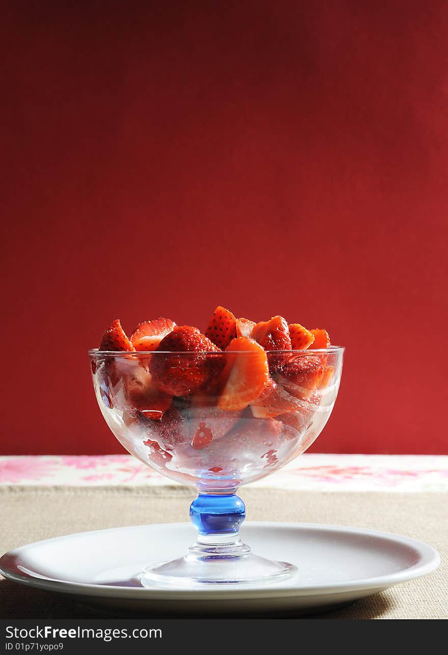 Cup of strawberries on red background