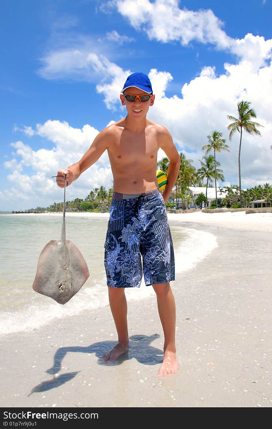 Teenager holding sting-ray on the florida beach. Teenager holding sting-ray on the florida beach