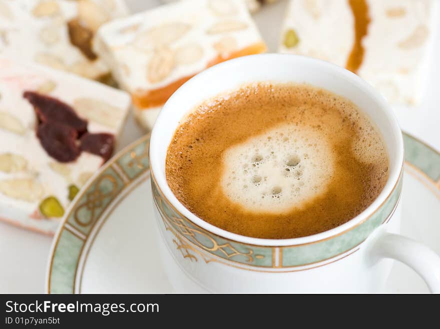 Breakfast composition with cup of fresh coffee and slices of nougat. Selective focus. Breakfast composition with cup of fresh coffee and slices of nougat. Selective focus.