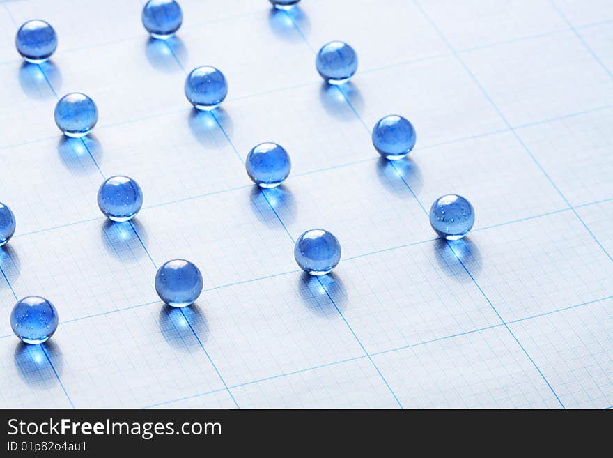 Background made from blue glass balls lying on squared paper