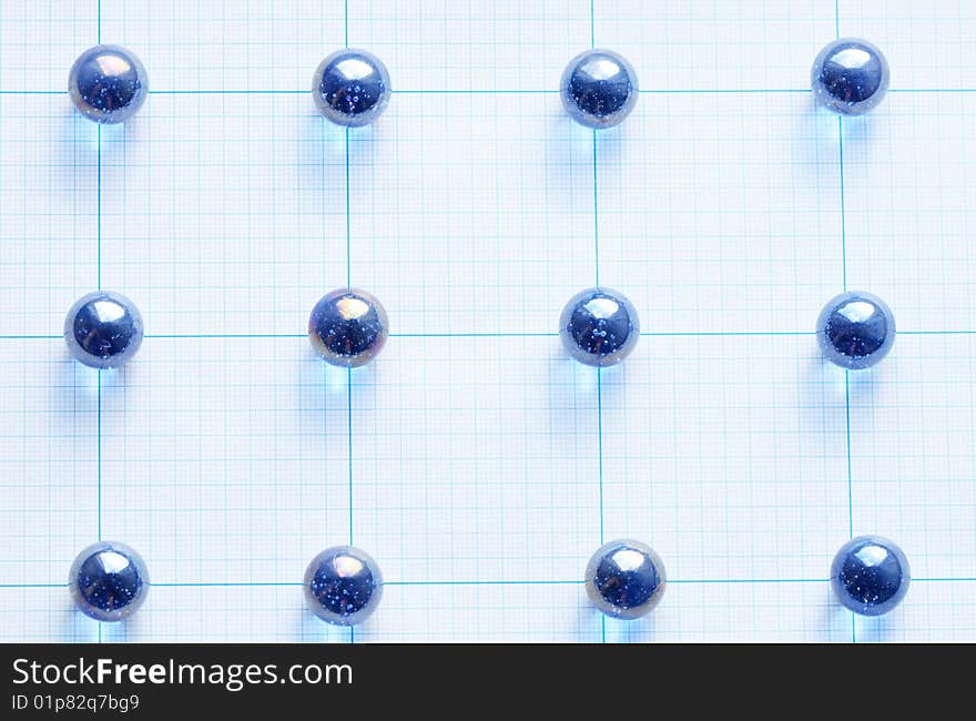 Background made from blue glass balls lying on squared paper