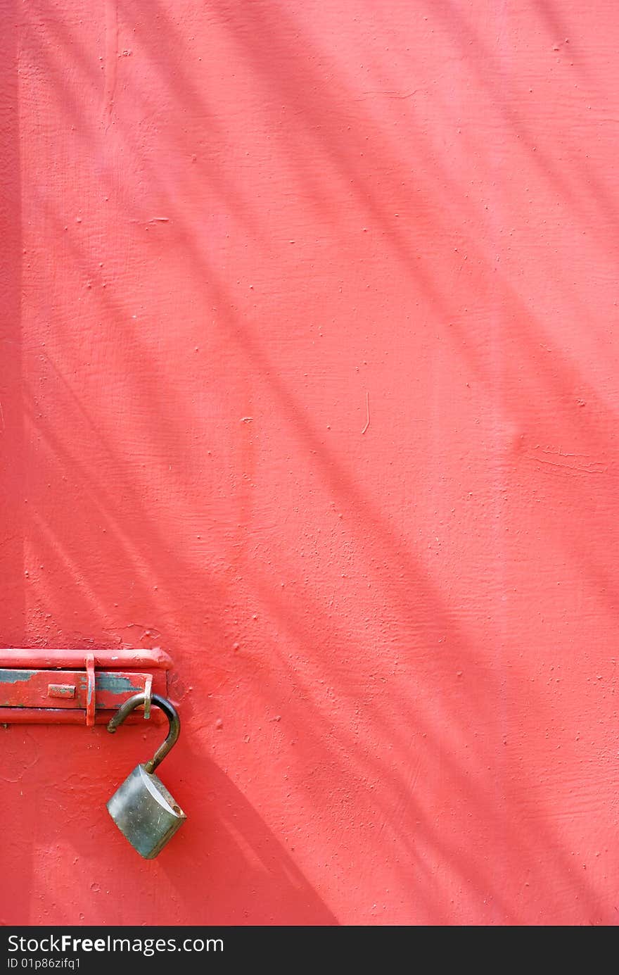 Metal padlock on red metal door