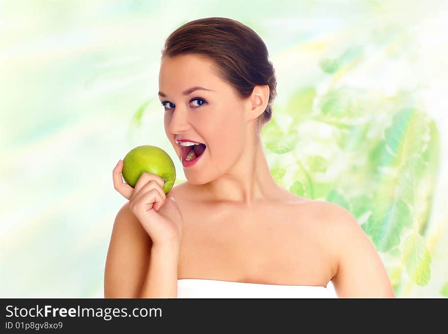 Young woman eating apple and smile over green background