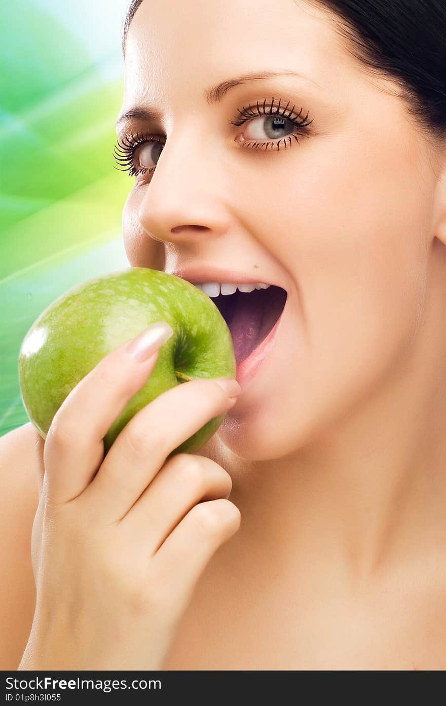 Young woman eating apple and smile over green background