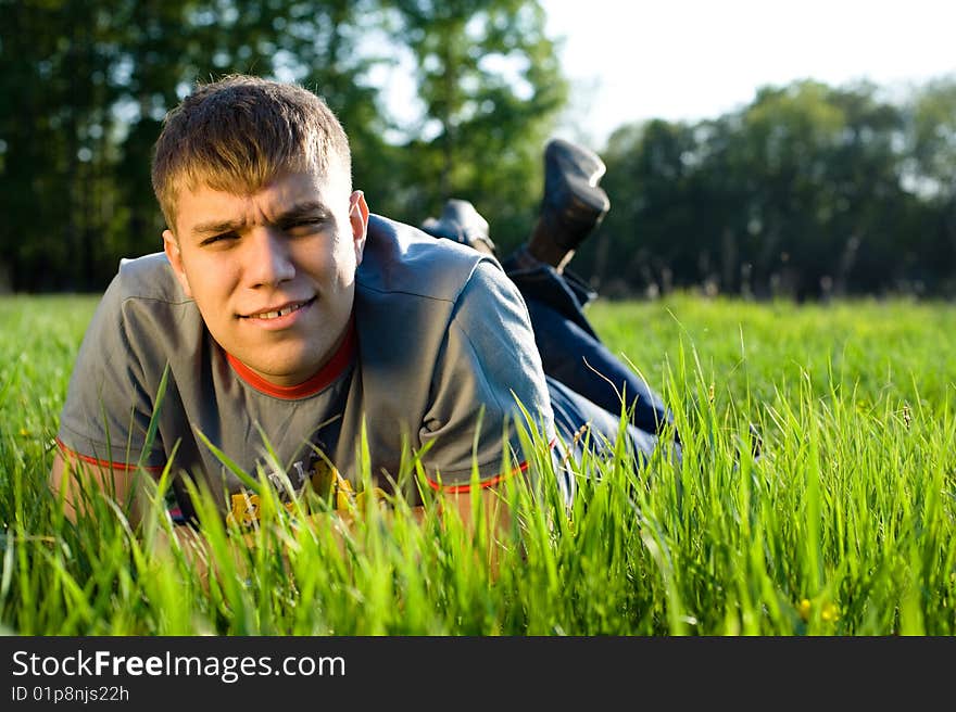 Young man lying down of grass. Copy space. Young man lying down of grass. Copy space