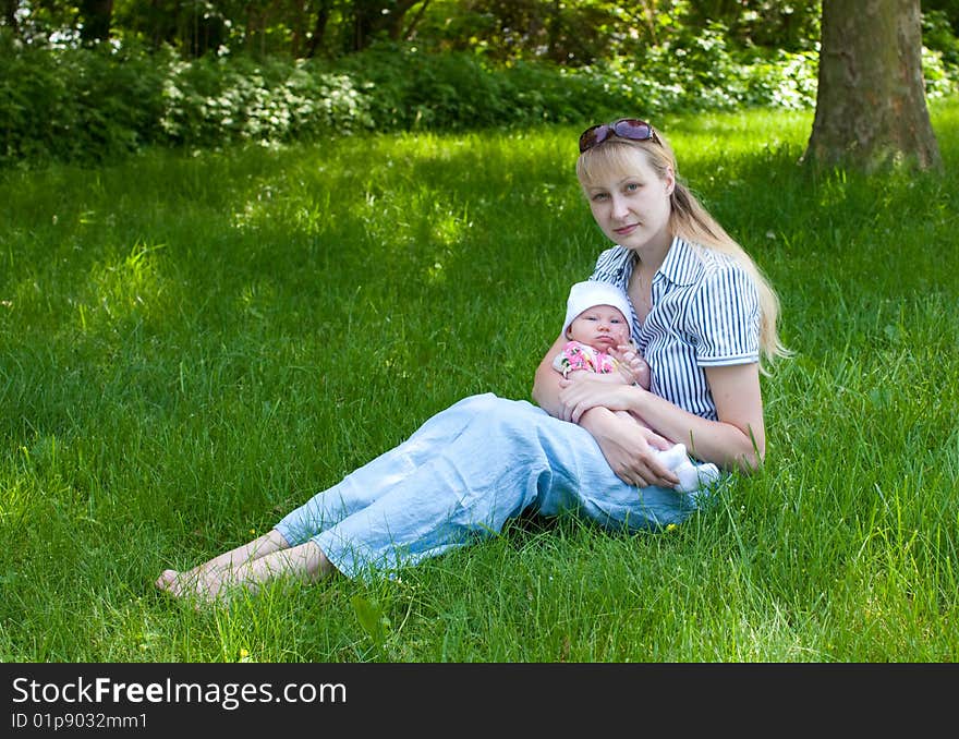 Baby And Mother Sitting In The Grass