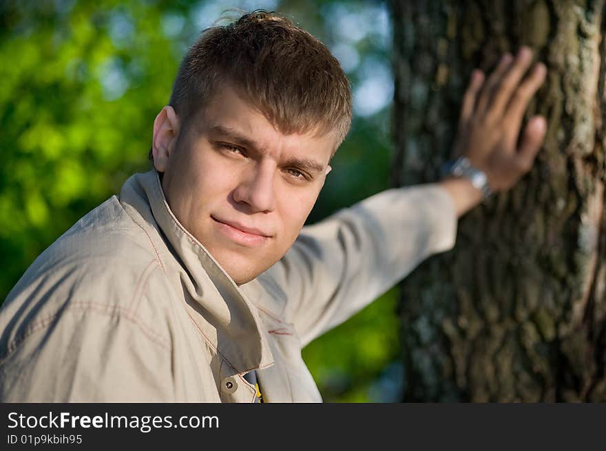 The young man holding from a tree