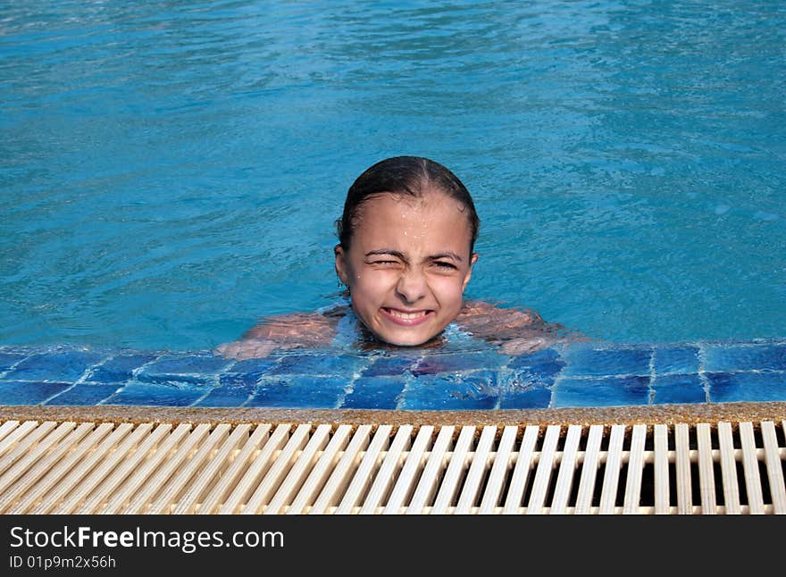 Beautiful girl in pool with blue water