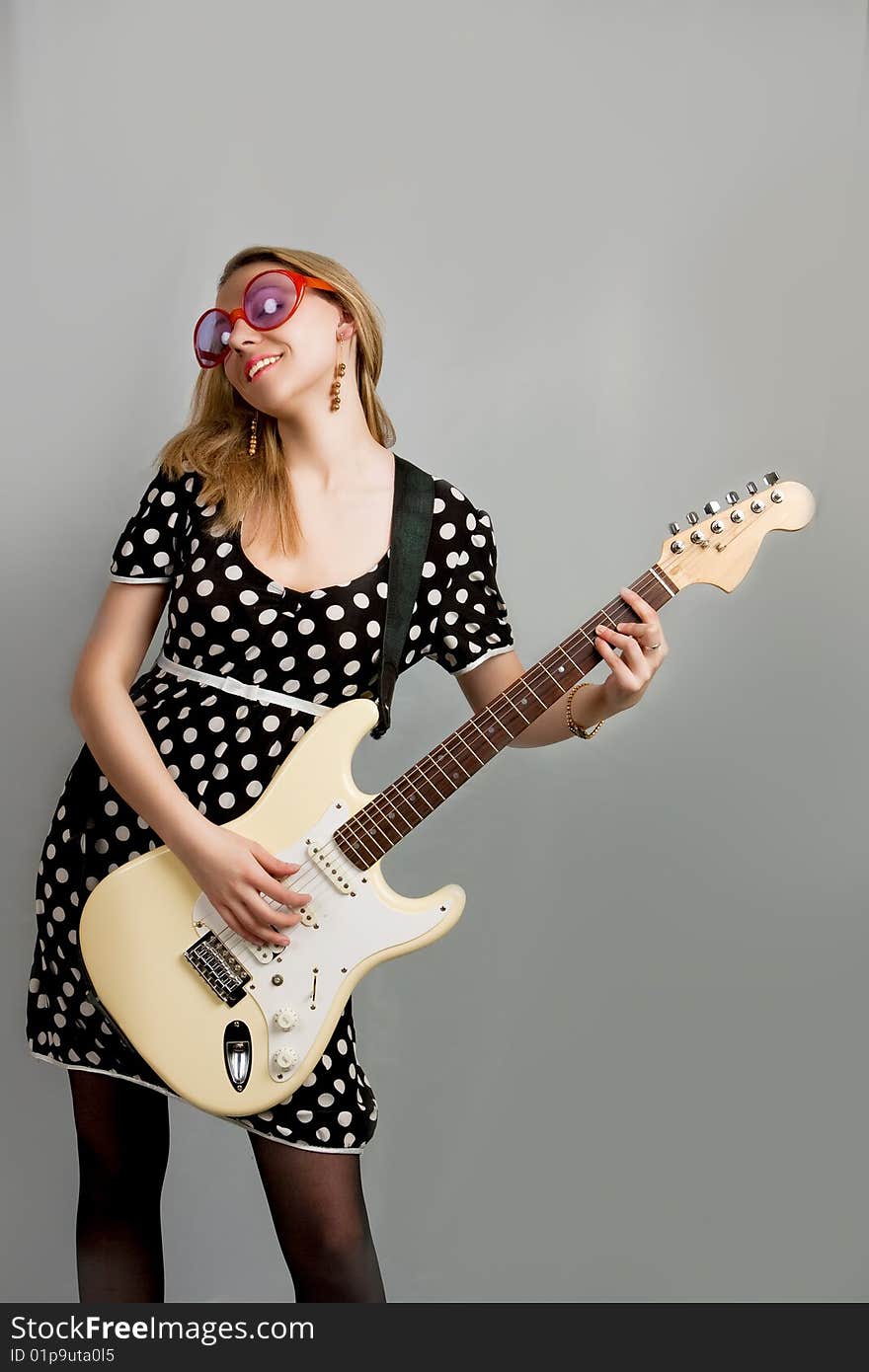 Young woman with guitar separated over grey background