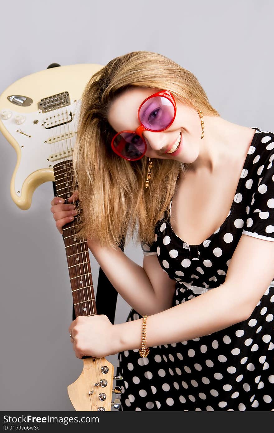 Girl having fun with guitar separated over grey background