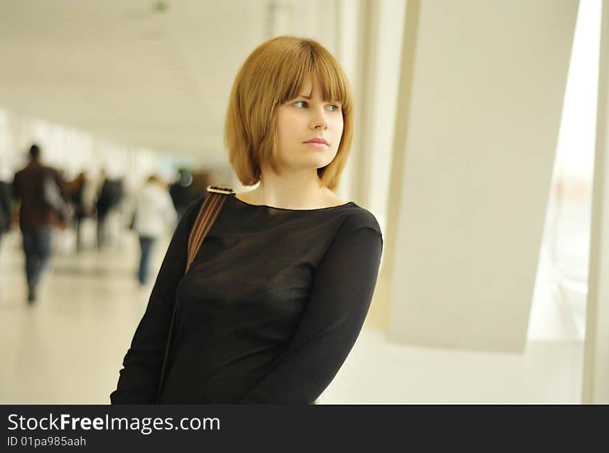 The nice girl looks in a window in shopping centre