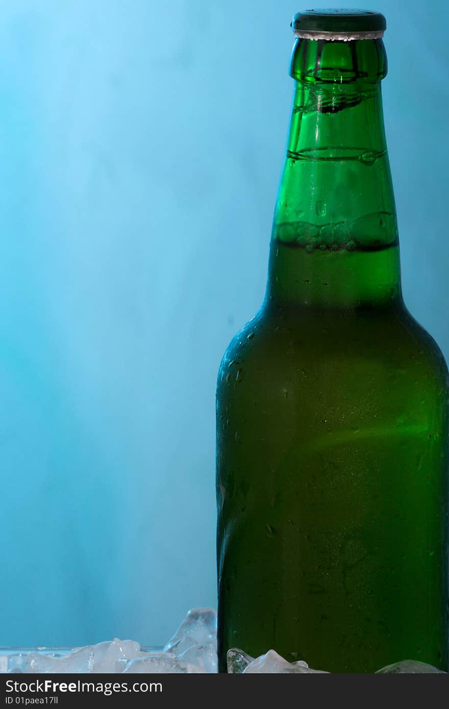 Beer in ice on blue abstract background