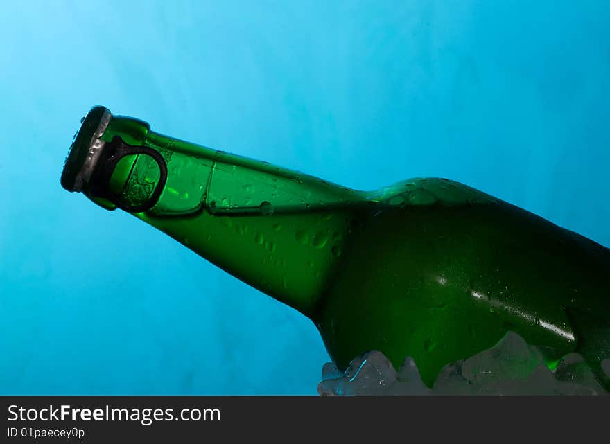 Beer in ice on blue abstract background