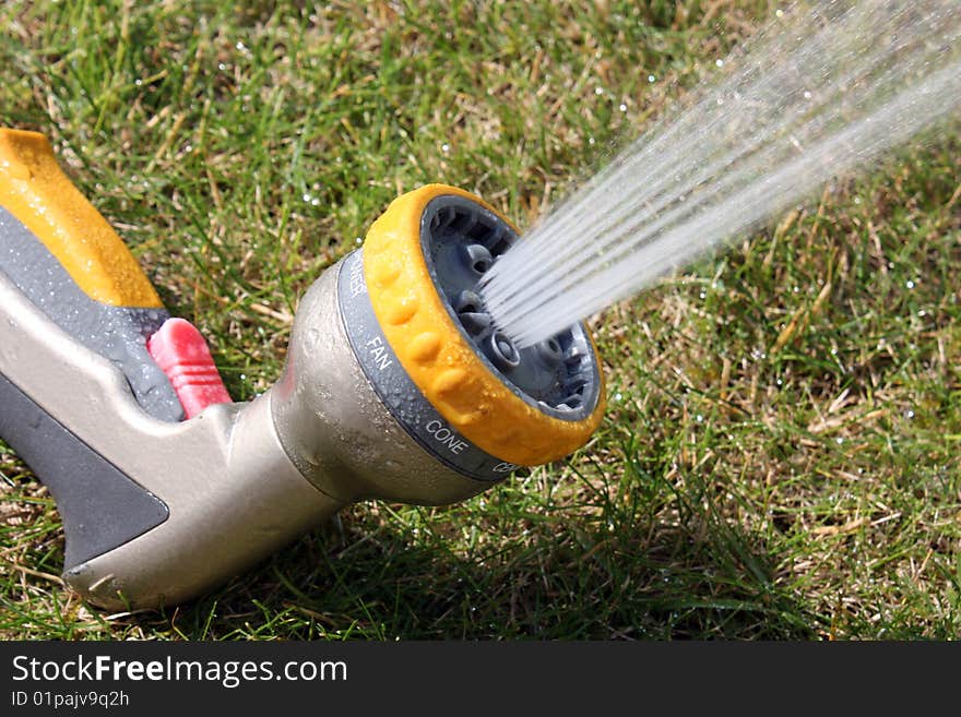 A used garden spraygun watering the garden. A used garden spraygun watering the garden