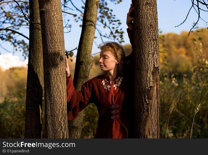 The blonde girl in medieval red dress in the autumn forest. The blonde girl in medieval red dress in the autumn forest