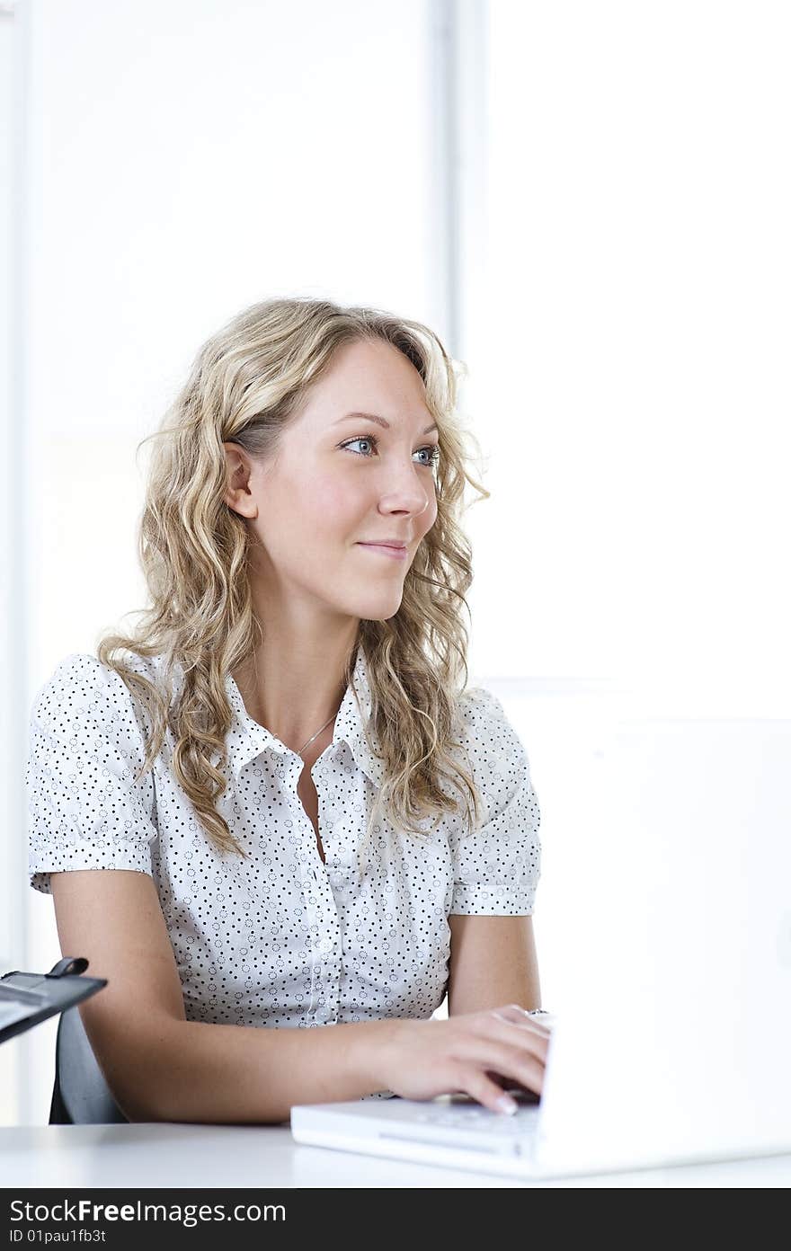 Young business woman in office with laptop